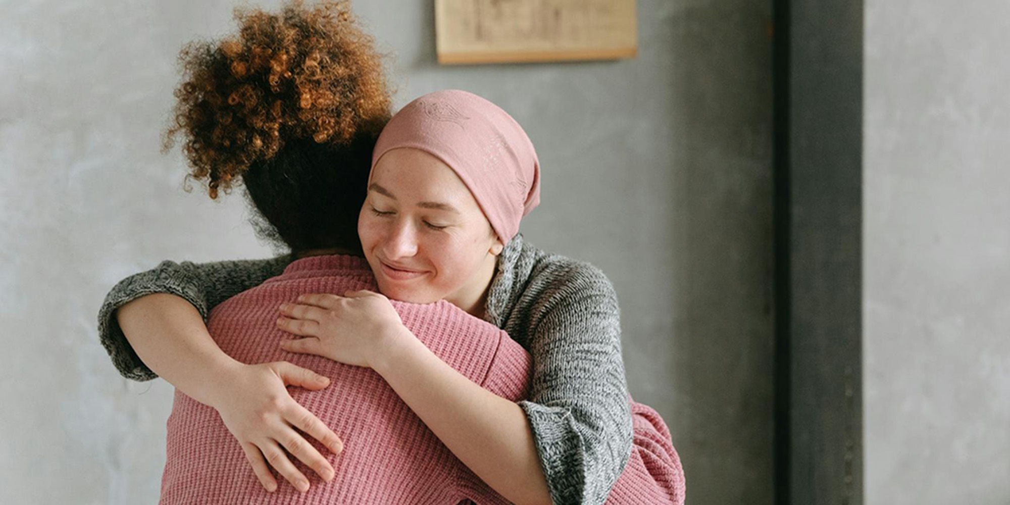 A cancer patient hugs a companion.