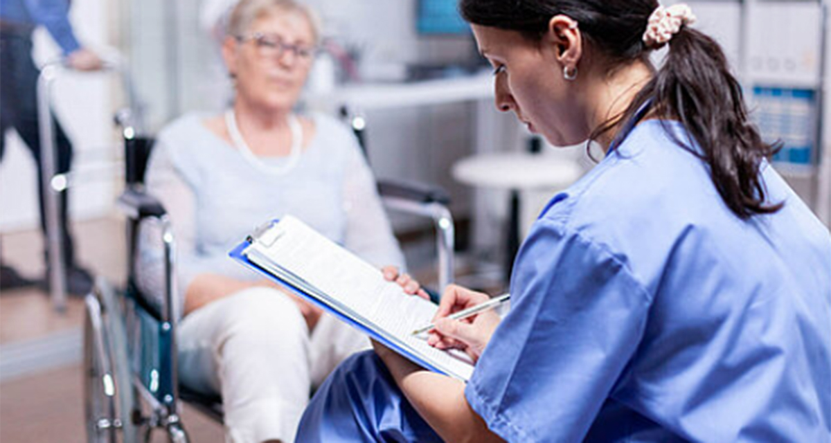 A patient in a wheelchair speaks to a doctor.