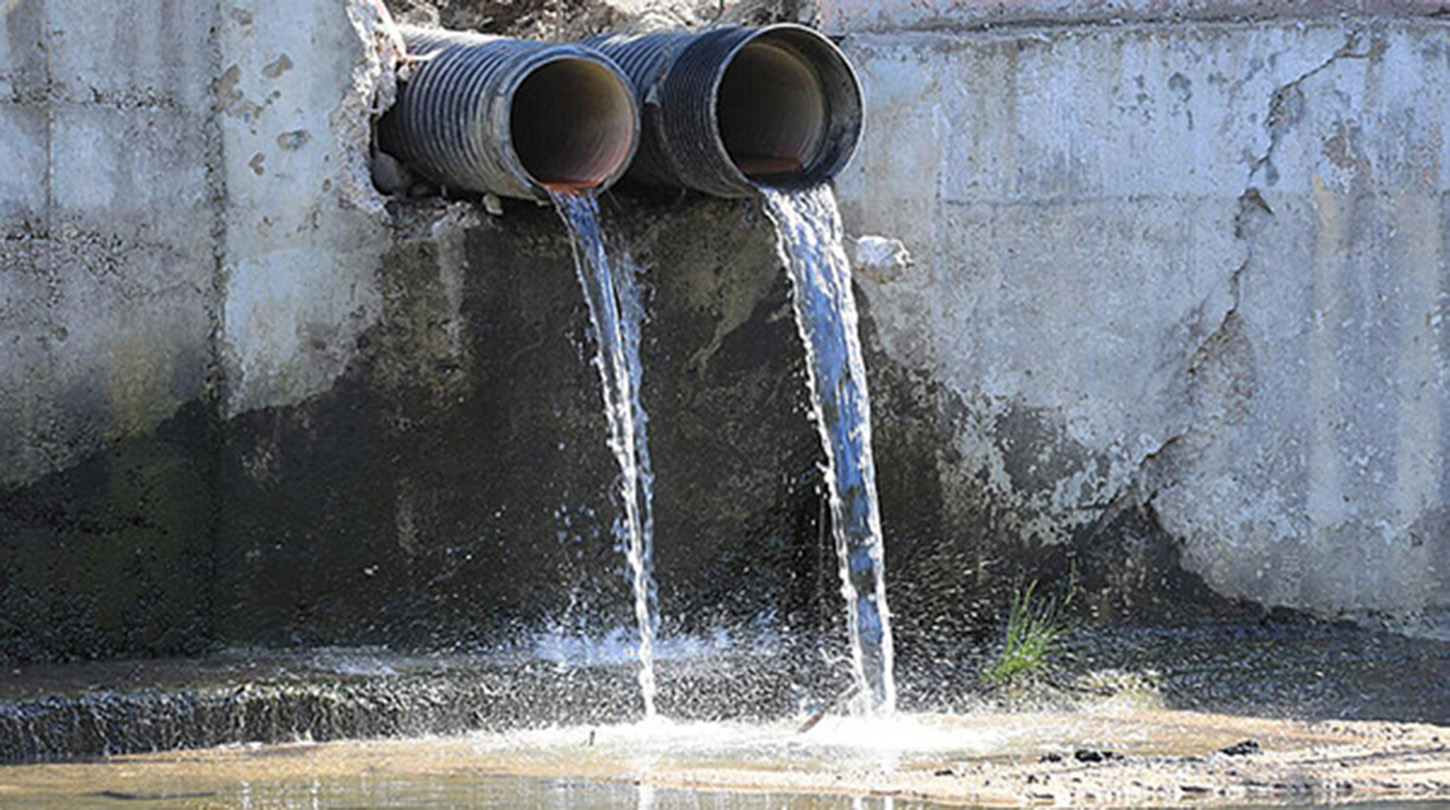 Murky water is discharged from pipes into the natural environment.