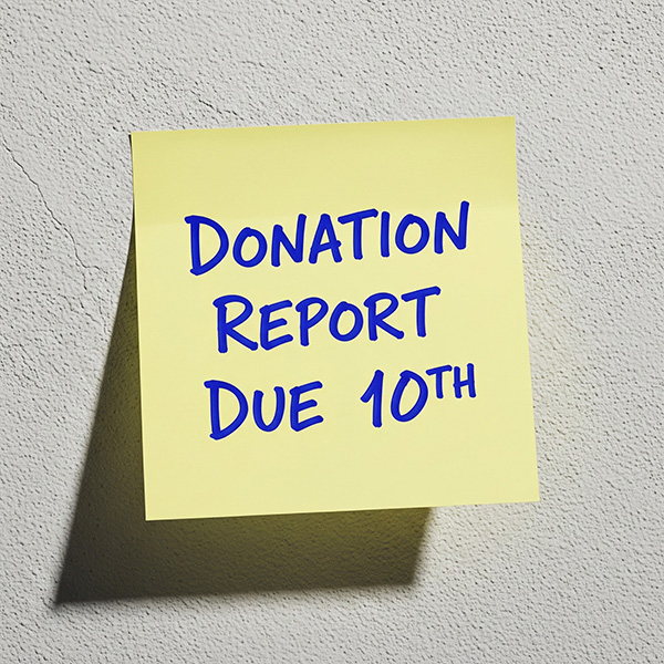 A sticky note saying Donation Report Due 10th