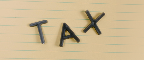 Plastic letters spelling out the word TAX on a notepad