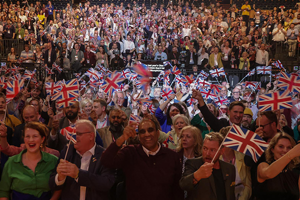 The audience at the rally waving flags