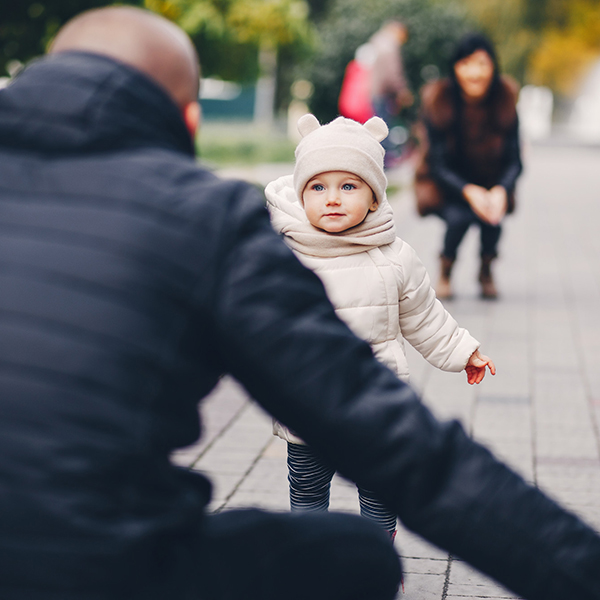 A child runs into their parent's open arms.