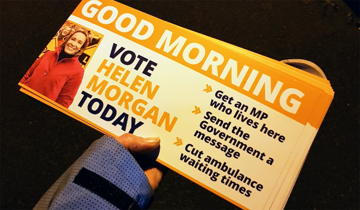 A hand holding a 'good morning' leaflet in the dark.