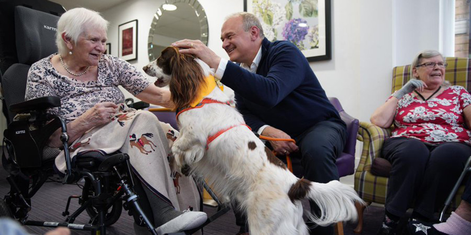 Ed Davey meets care home residents with a dog.