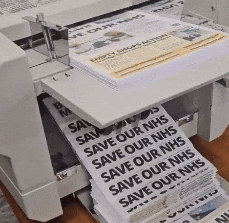 A printer prints out literature which reads 'SAVE OUR NHS'