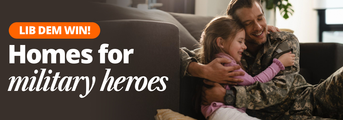 Lib Dem win! Homes for military heroes. Image of parent in military uniform hugging their child on a sofa.