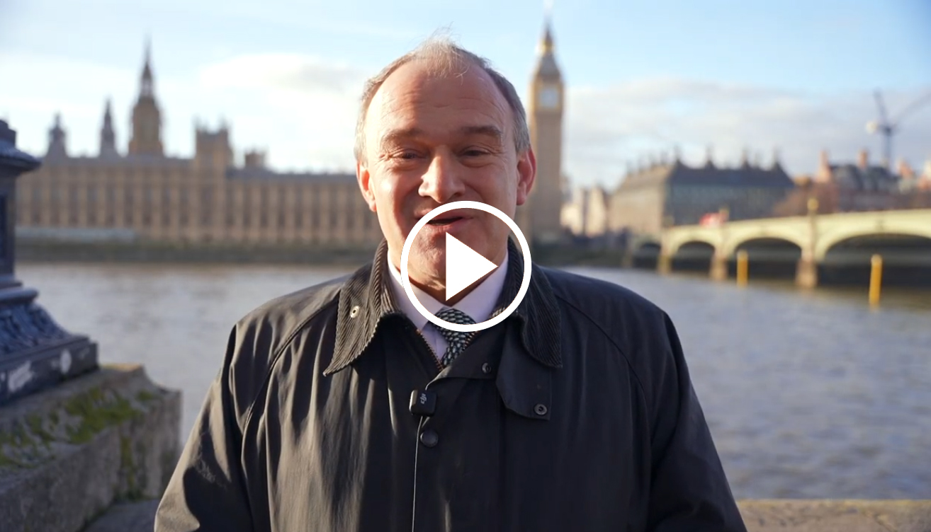 Ed Davey standing in front of the Houses of Parliament