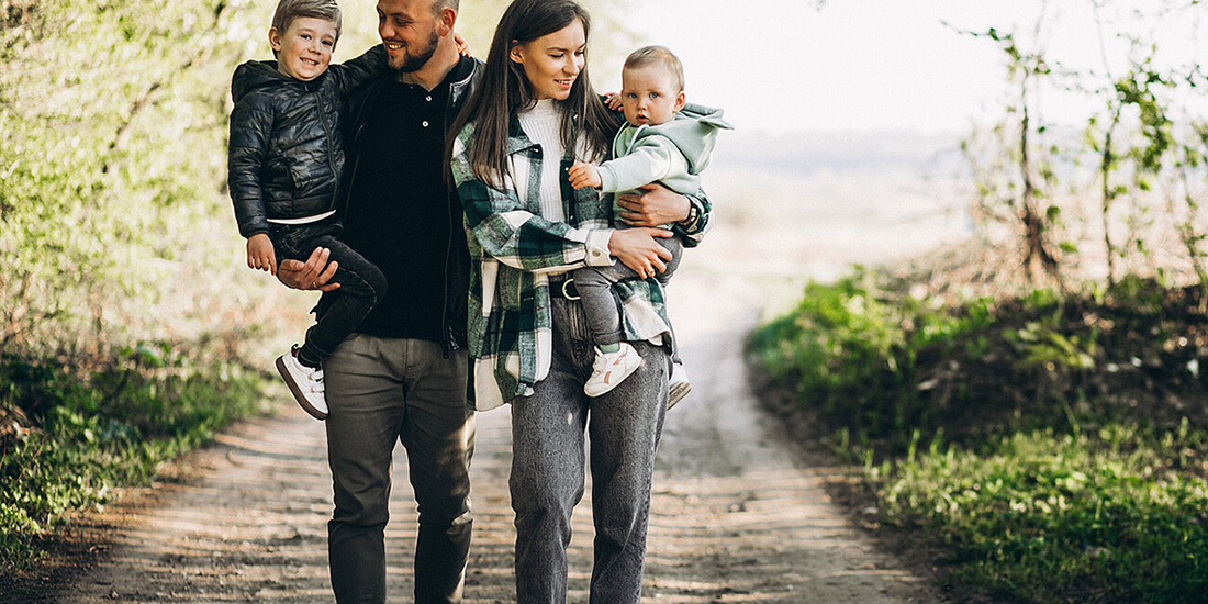 A family walk down a road together.