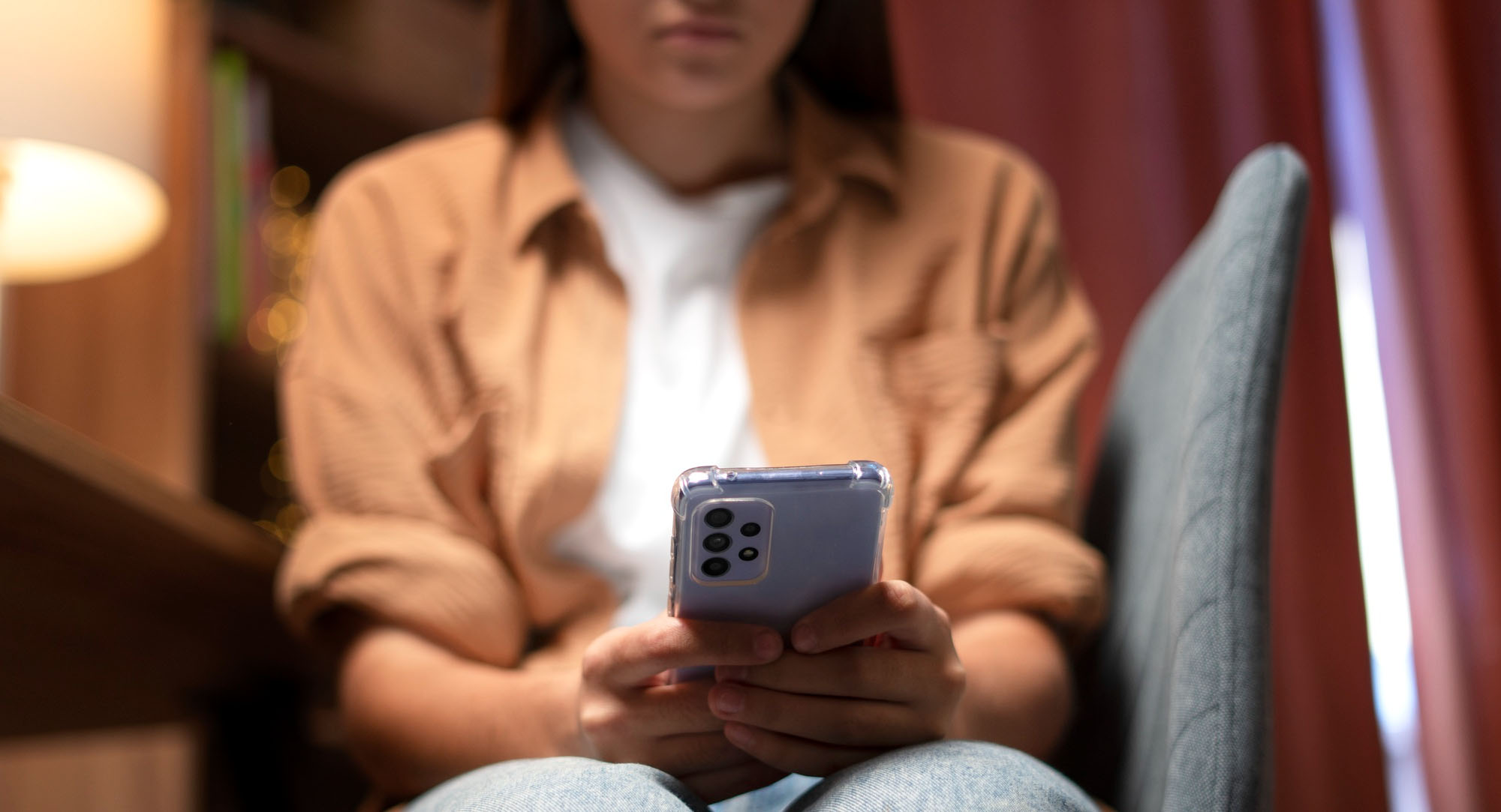 A girl looking glumly at her phone